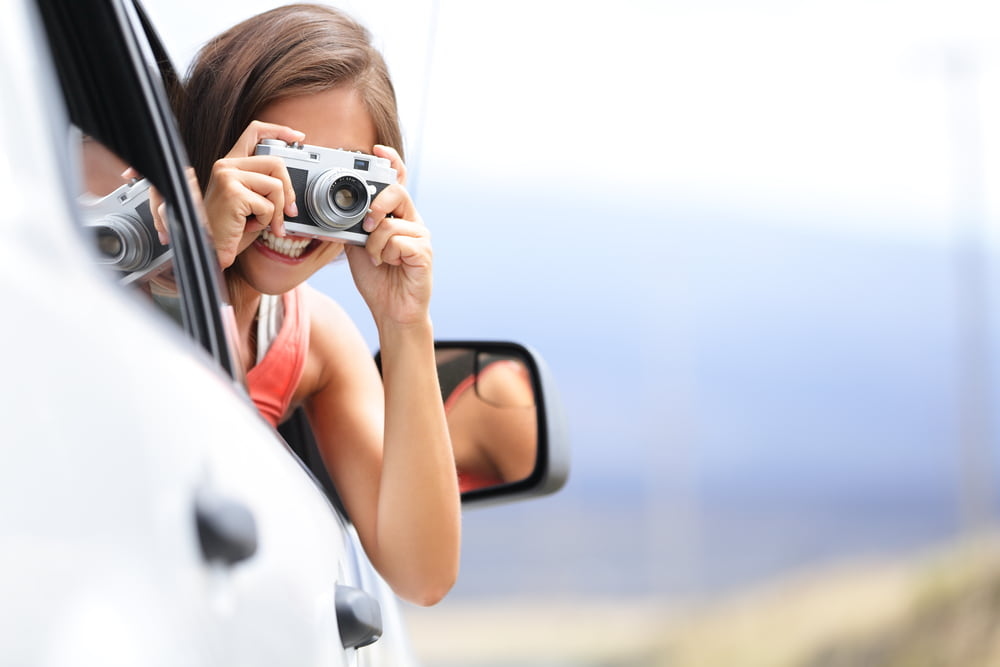 Girl passenger taking picture out of window