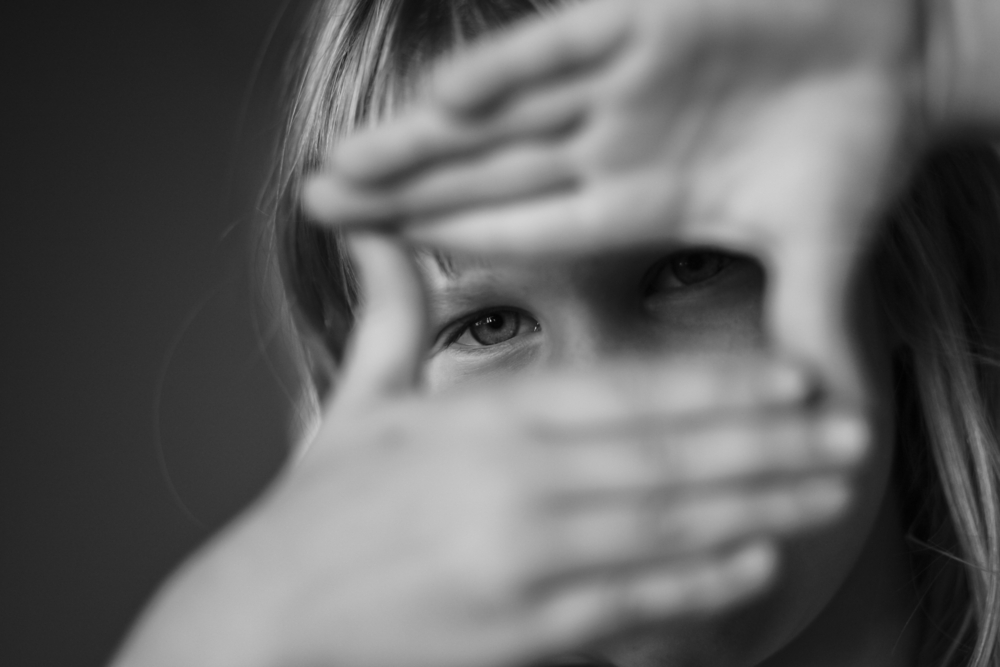 Young girl looking through hand as a director and cameraman