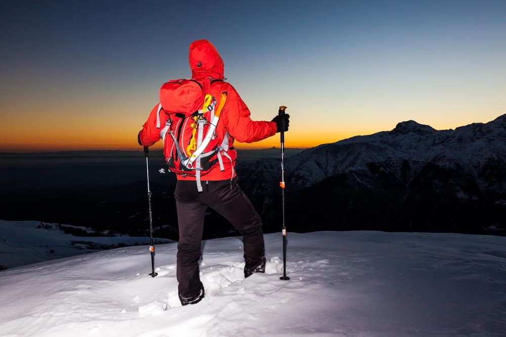 man stands on a snowy ridge 